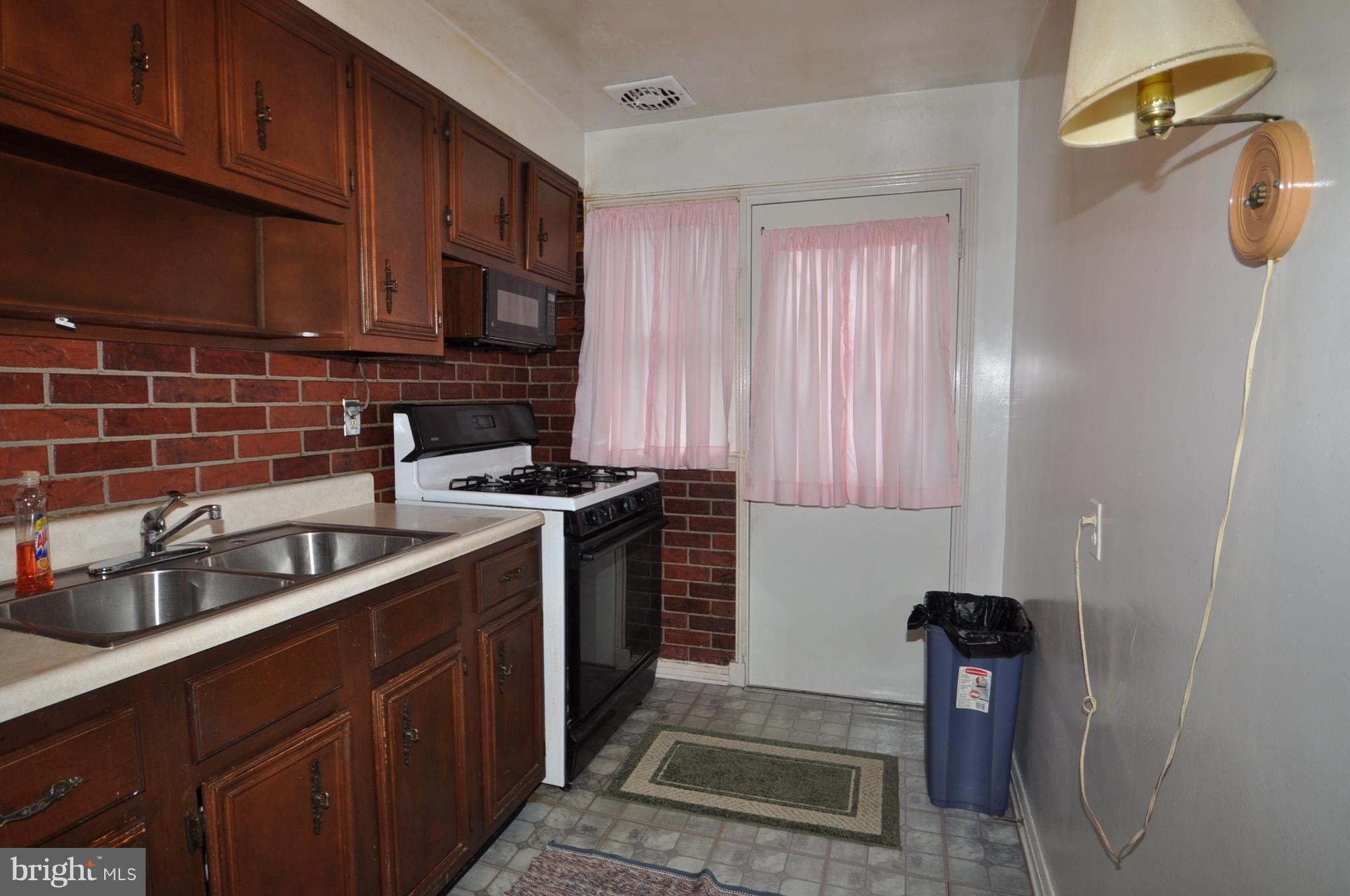 7438 Durwood Road Baltimore, MD 21222 - Photo 6 of 20 a kitchen with stainless steel appliances granite countertop a sink stove and cabinets