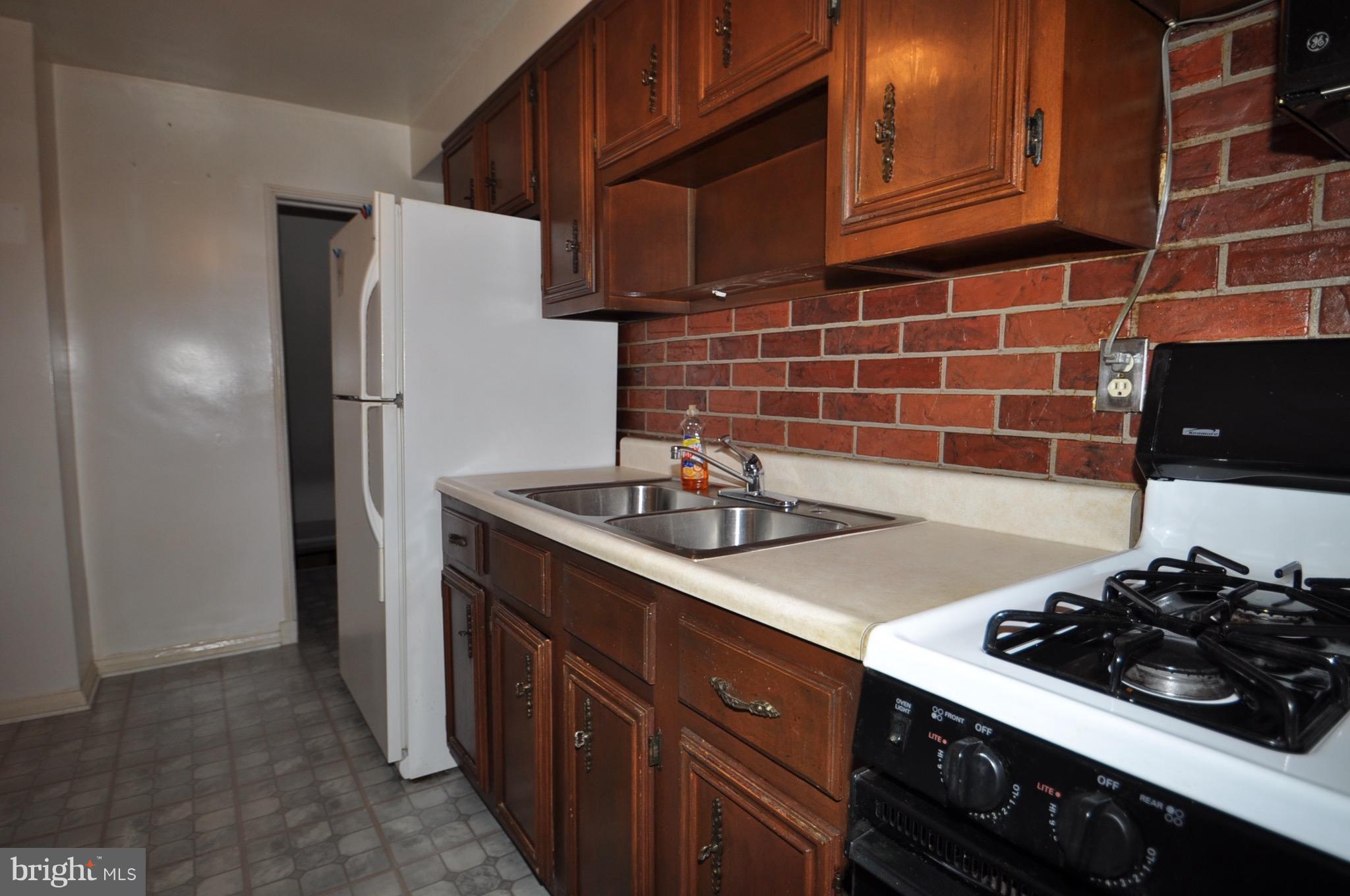 7438 Durwood Road Baltimore, MD 21222 - Photo 7 of 20 a kitchen with stainless steel appliances a sink stove and refrigerator
