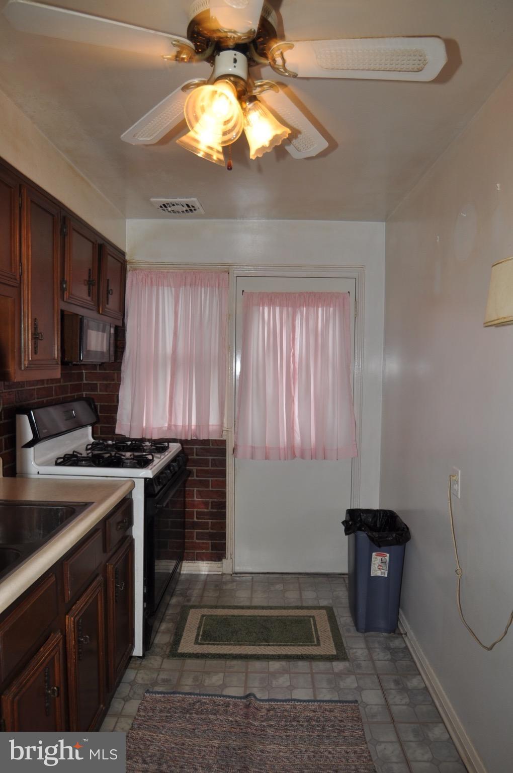7438 Durwood Road Baltimore, MD 21222 - Photo 8 of 20 a kitchen with a stove a microwave and cabinets
