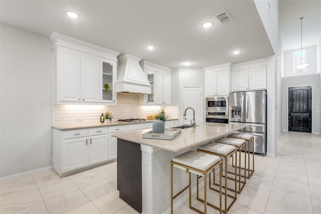2176 Olive Branch Road Frisco, TX 75033 - Photo 7 of 35 a kitchen with stainless steel appliances granite countertop a sink a stove a refrigerator and cabinets