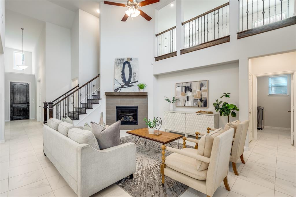 2176 Olive Branch Road Frisco, TX 75033 - Photo 10 of 35 a living room with furniture a fireplace and a chandelier