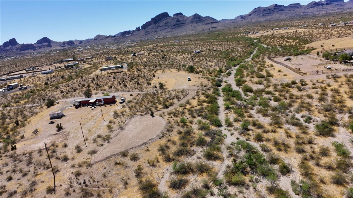 1386 Don Luis Road Golden Valley, AZ 86413 - Photo 41 of 47 Expansive property with a desert landscape, featuring a residence with a red roof, a separate outbuilding, and distant mountain views