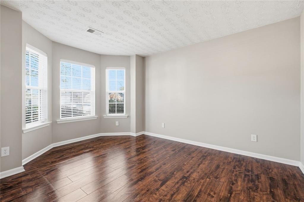 3570 Bogan Mill Road Northeast Buford, GA 30519 - Photo 10 of 31 a view of an empty room with wooden floor and a window
