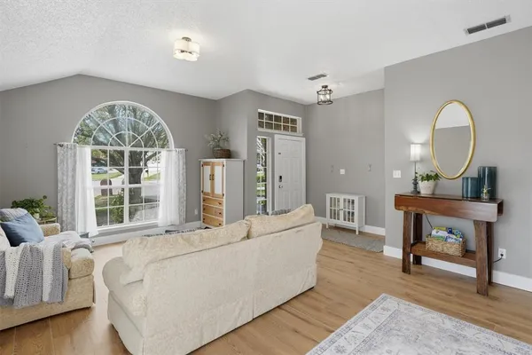 a living room with furniture a fireplace and a large window