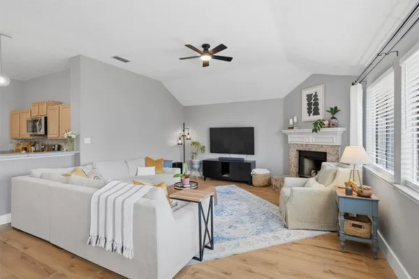 a living room with furniture a fireplace and a flat screen tv