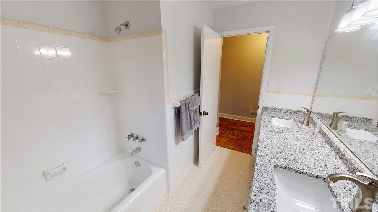 108 Rand Road Raleigh, NC 27603 - Photo 16 of 29 Tub has beautiful tile shower surround. Bathroom floor is tile too.