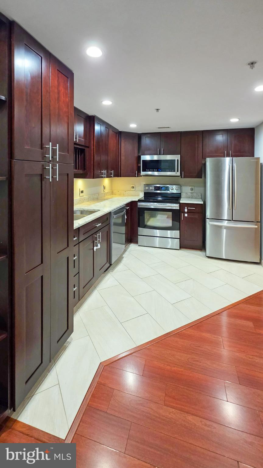 2301 N Street Northwest, Unit 404 Washington, DC 20037 - Photo 3 of 21 a kitchen with stainless steel appliances kitchen island granite countertop a refrigerator and a stove top oven