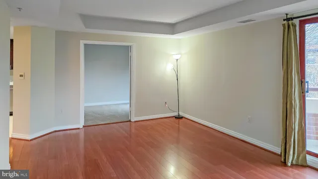 an empty room with wooden floor and closet
