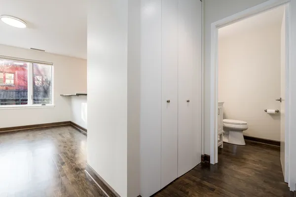 a view of a hallway with wooden floor and a window