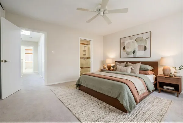 a spacious bedroom with a bed and a painting on the wall