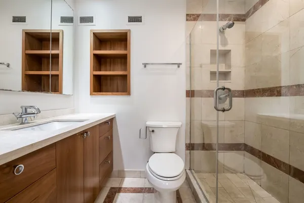 a bathroom with a granite countertop sink toilet and shower