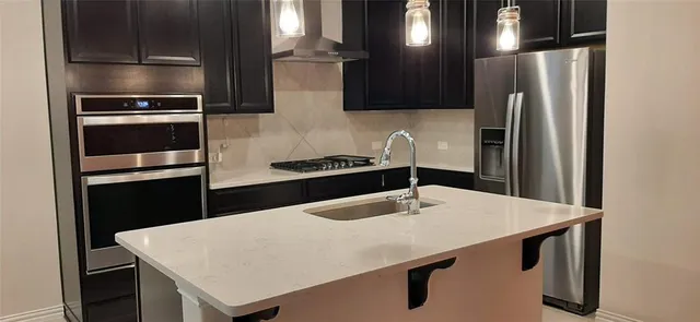 a kitchen with stainless steel appliances a refrigerator and a stove