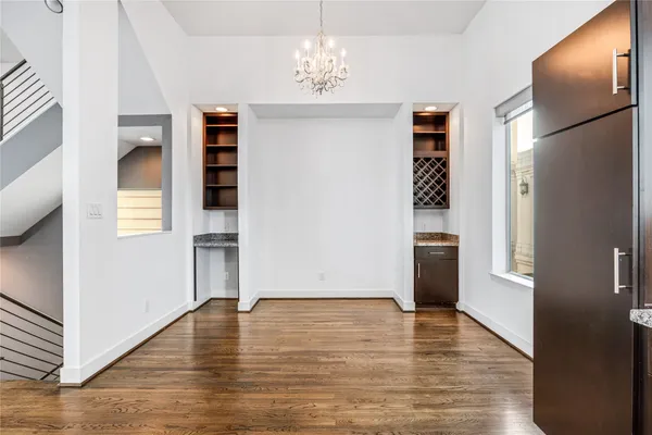 a view of empty room with wooden floor and window