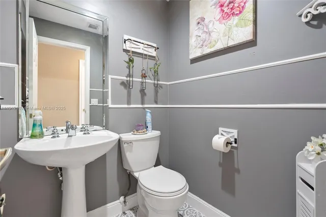 a bathroom with a toilet a sink and mirror
