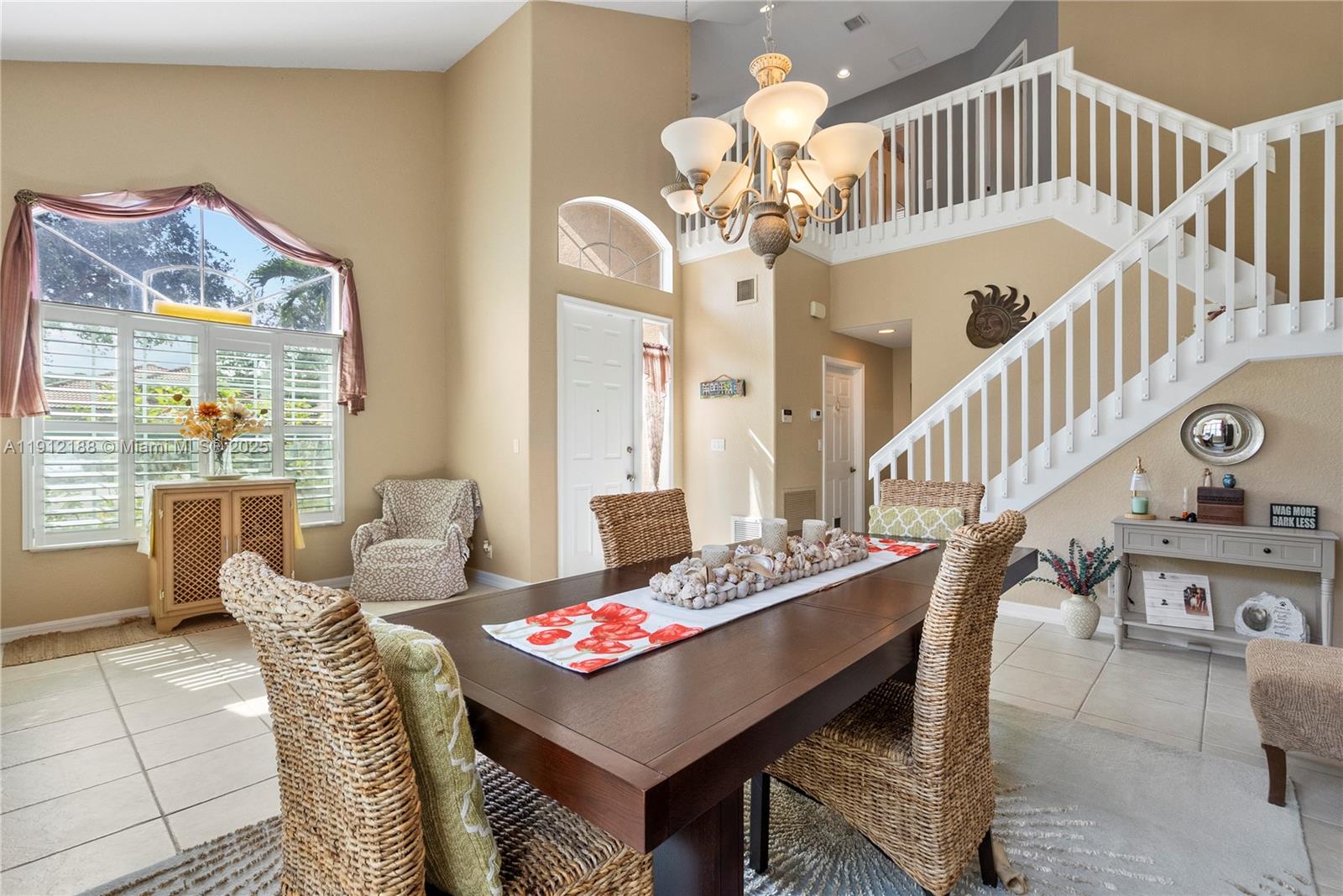 2795 Southeast Stonebriar Way Stuart, FL 34997 - Photo 18 of 54 a view of a dining room with furniture a chandelier and wooden floor