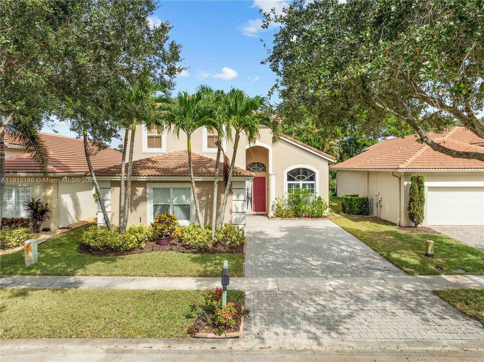 2795 Southeast Stonebriar Way Stuart, FL 34997 - Photo 2 of 54 a front view of a house with a garden