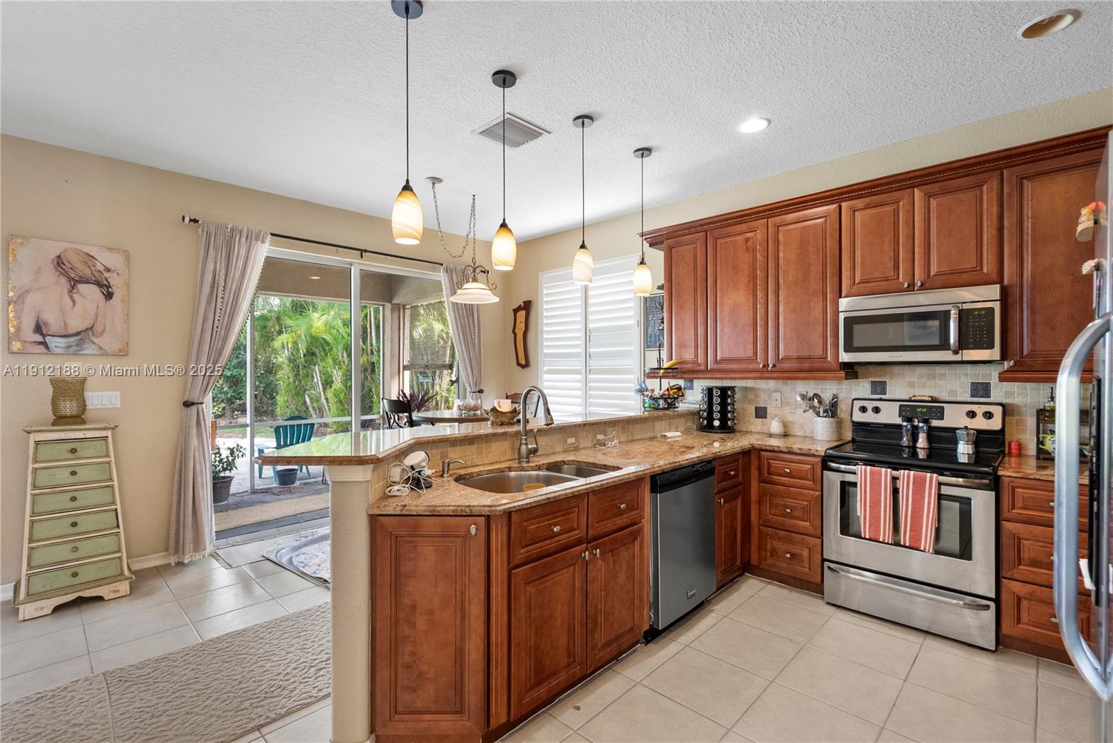 2795 Southeast Stonebriar Way Stuart, FL 34997 - Photo 26 of 54 a kitchen with stainless steel appliances a sink stove and cabinets