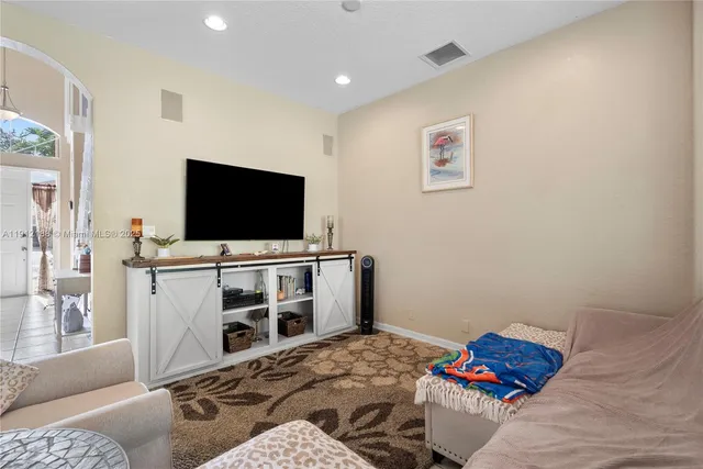 a living room with patio furniture and a potted plant