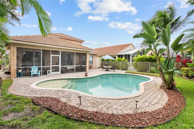 a patio with a table and chairs and potted plants