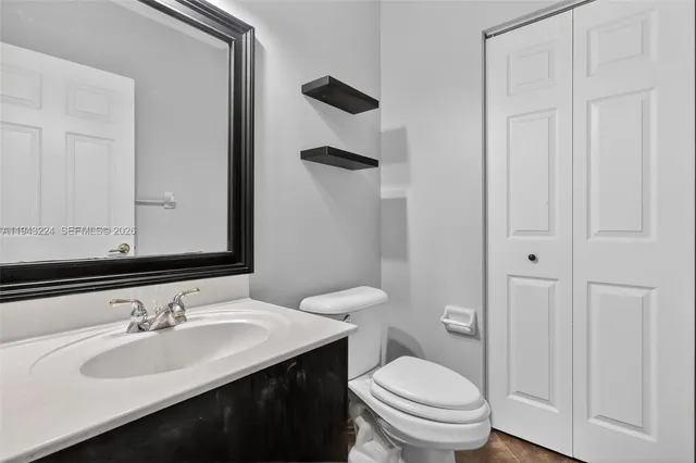 a bathroom with a sink a toilet a mirror and shower