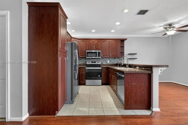 a kitchen with stainless steel appliances granite countertop a refrigerator and a stove top oven