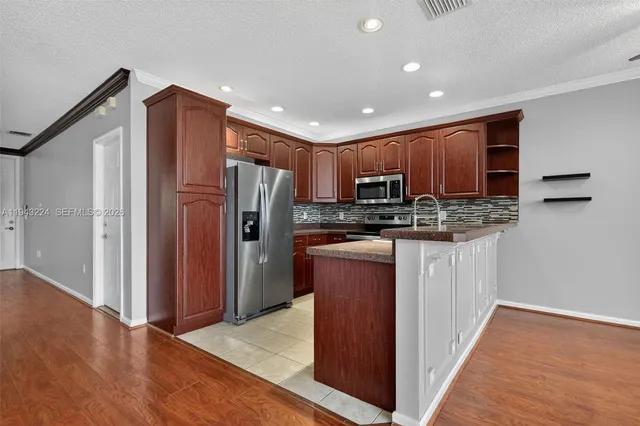 a kitchen with granite countertop cabinets stainless steel appliances and microwave