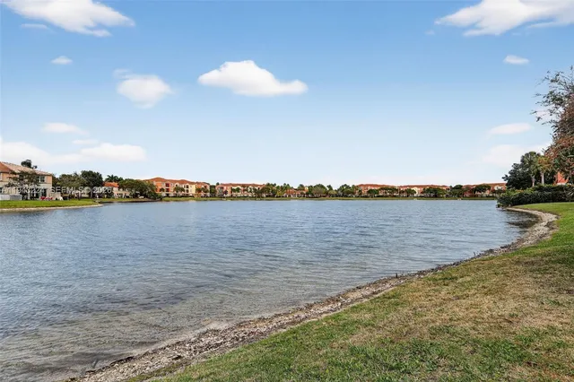 an aerial view of a house with yard and trees in the background