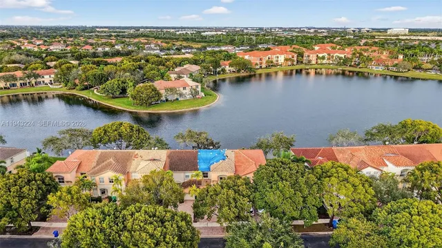 an aerial view of residential houses with outdoor space and lake view
