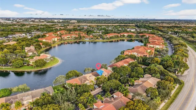 an aerial view of ocean and residential houses with outdoor space