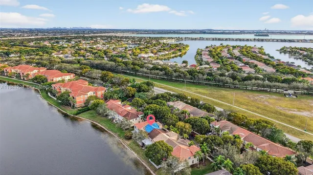 an aerial view of residential houses with outdoor space and lake view