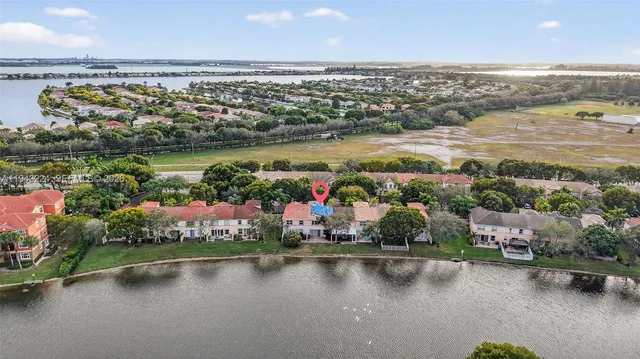 an aerial view of residential houses with outdoor space and lake view