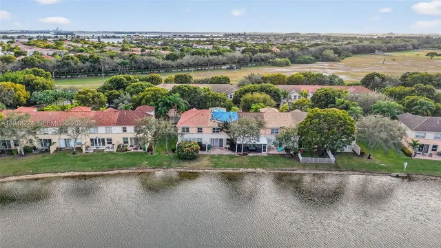 an aerial view of residential houses with outdoor space and lake view