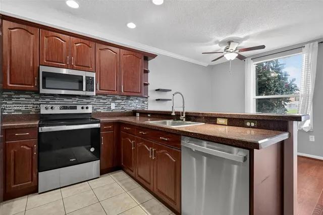 a kitchen with stainless steel appliances granite countertop a refrigerator and a stove