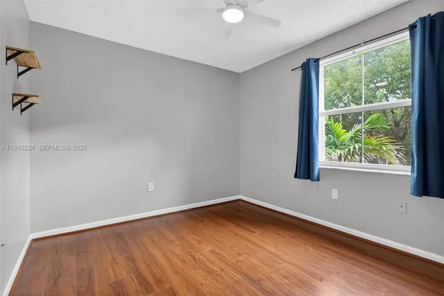 a view of an empty room with wooden floor