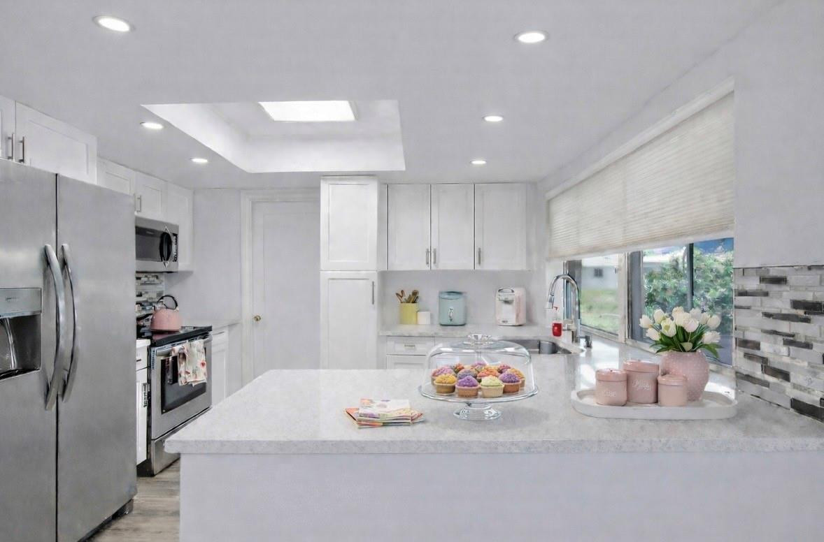6755 Northwest 15th Street Margate, FL 33063 - Photo 6 of 11 a kitchen with stainless steel appliances kitchen island granite countertop a refrigerator and a sink