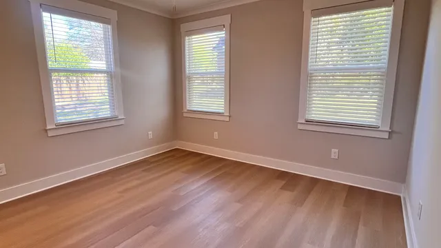 an empty room with wooden floor and a window