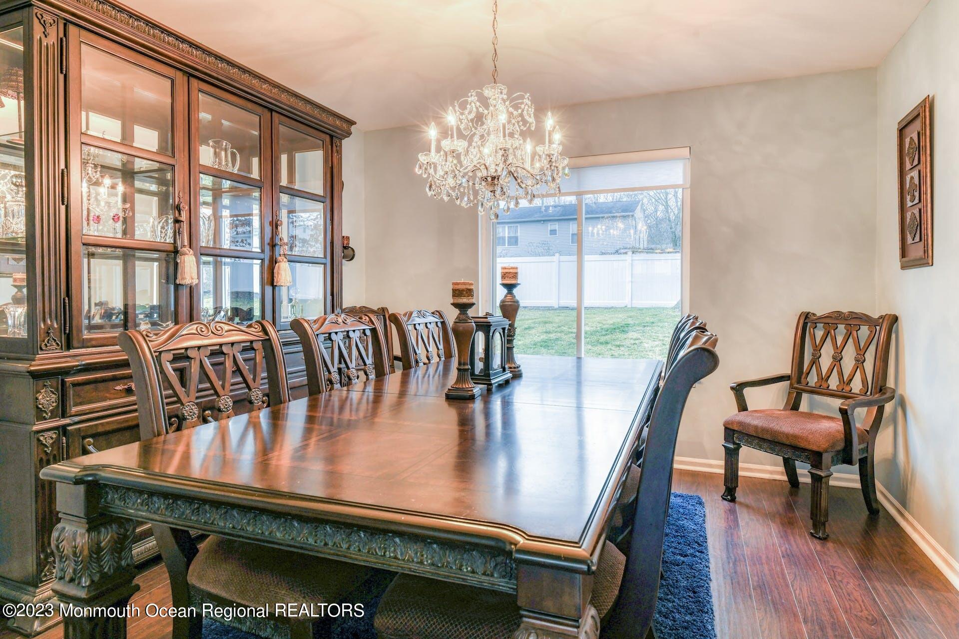 98 Starlight Road Howell, NJ 07731 - Photo 7 of 31 a dining room with furniture a chandelier and wooden floor