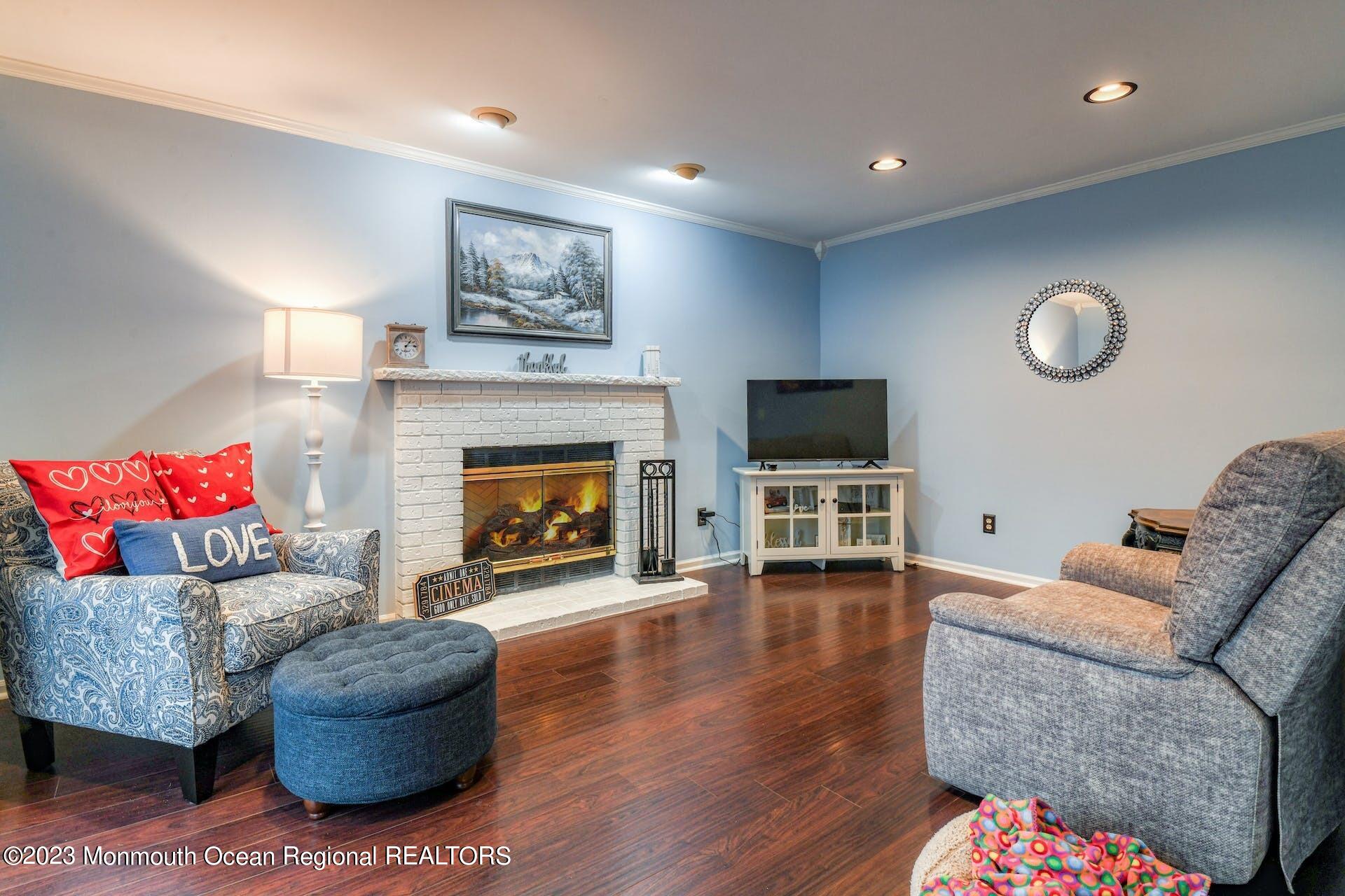 98 Starlight Road Howell, NJ 07731 - Photo 8 of 31 a living room with furniture a flat screen tv and a fireplace