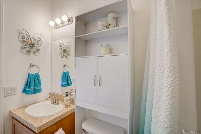 a bathroom with a sink vanity mirror and toilet