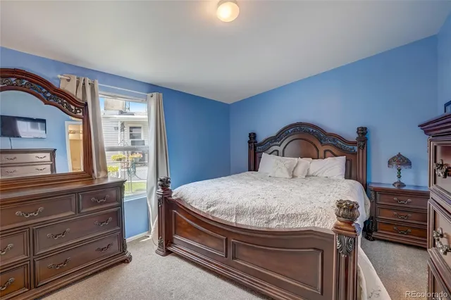 a bedroom with a bed and a dresser with mirror