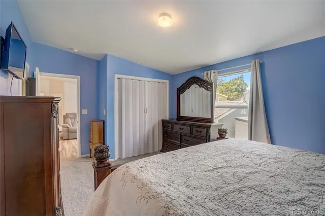 a bedroom with a bed dresser and a flat tv screen