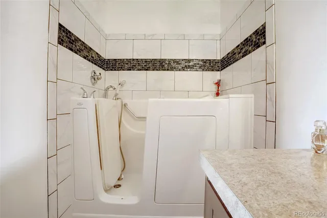 a bathroom with a granite countertop shower and a sink