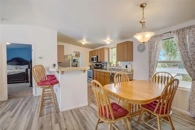 a dining room with furniture a chandelier and wooden floor