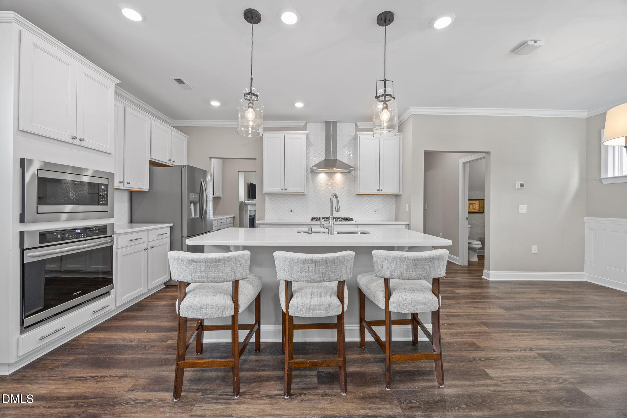 217 Masden Road Holly Springs, NC 27540 - Photo 10 of 32 a kitchen with stainless steel appliances kitchen island granite countertop a dining table chairs sink and microwave