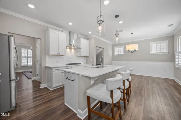 a kitchen with stainless steel appliances kitchen island granite countertop a sink stove and refrigerator