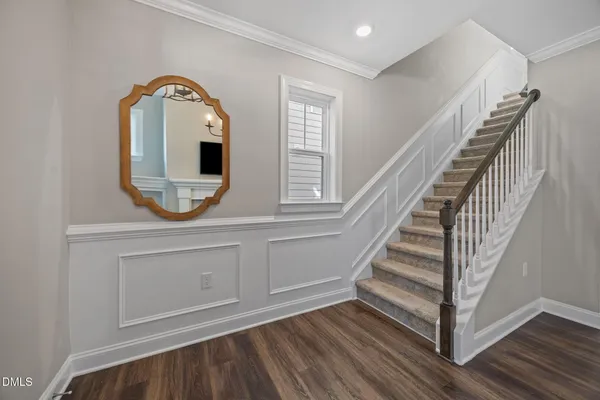 a large kitchen with cabinets wooden floor white stainless steel appliances and view living room