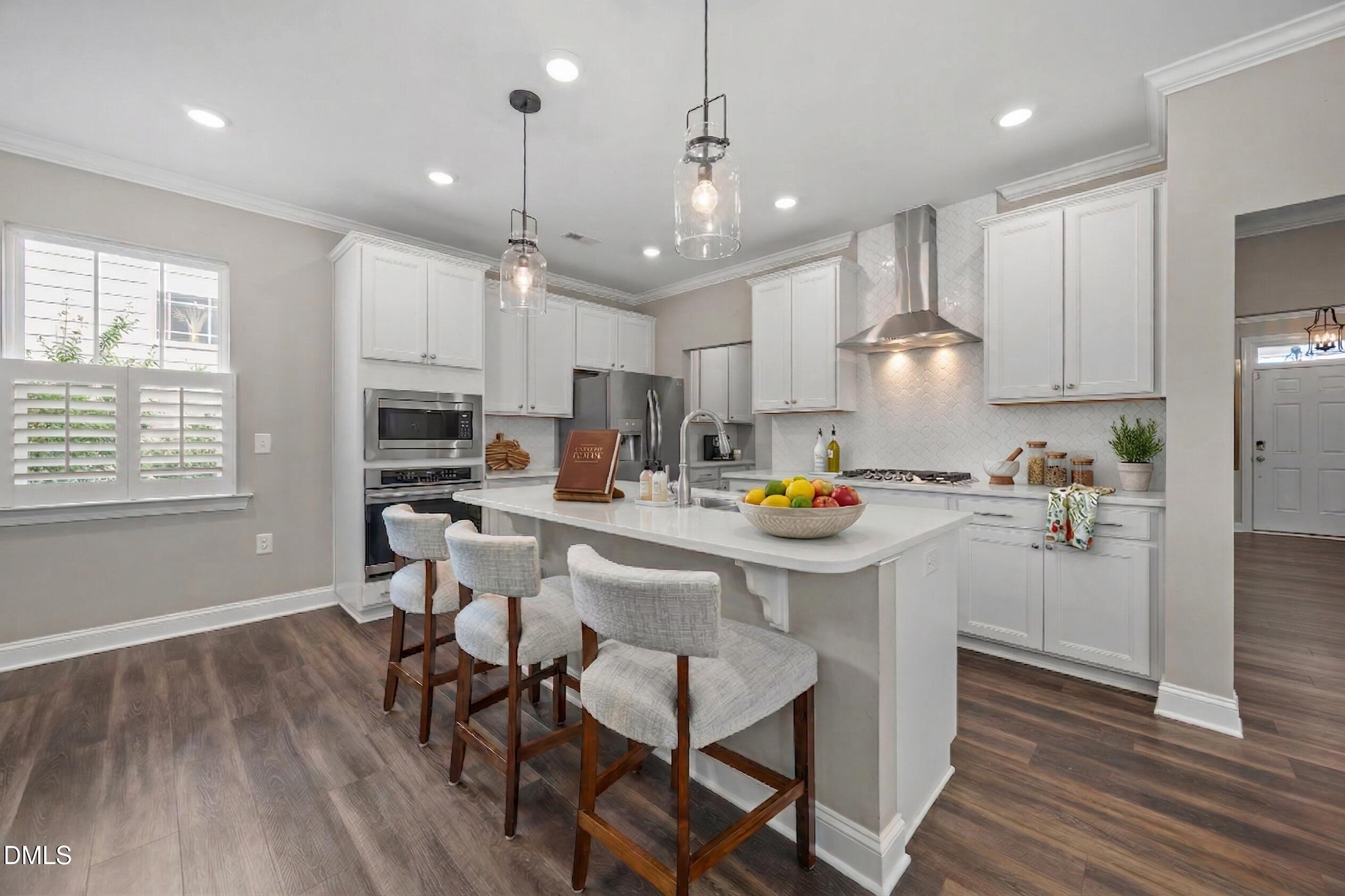 217 Masden Road Holly Springs, NC 27540 - Photo 8 of 32 a kitchen with stainless steel appliances a dining table chairs stove microwave and cabinets