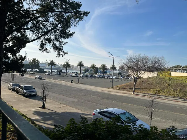 a view of a street with large trees