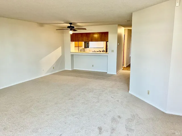 an empty room with windows and fireplace
