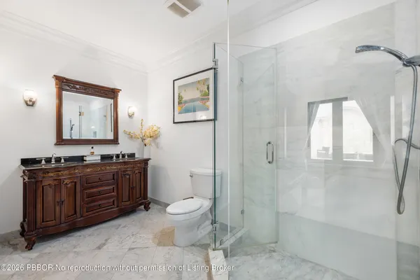 a bathroom with a sink a toilet and shower a mirror